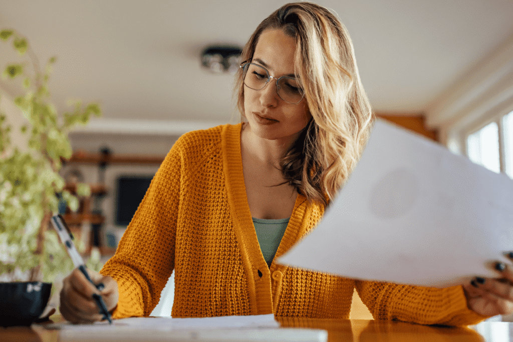 Woman sitting in home looking at papers